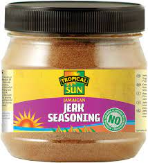 Tropical Sun Jerk Seasoning in a clear jar with yellow label and black lid showcasing authentic Jamaican spices for bold Caribbean flavor