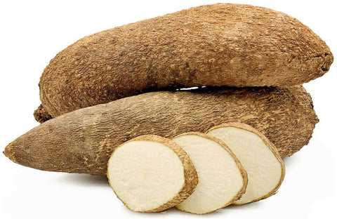 Fresh yam tubers with sliced pieces showing white interior on white background